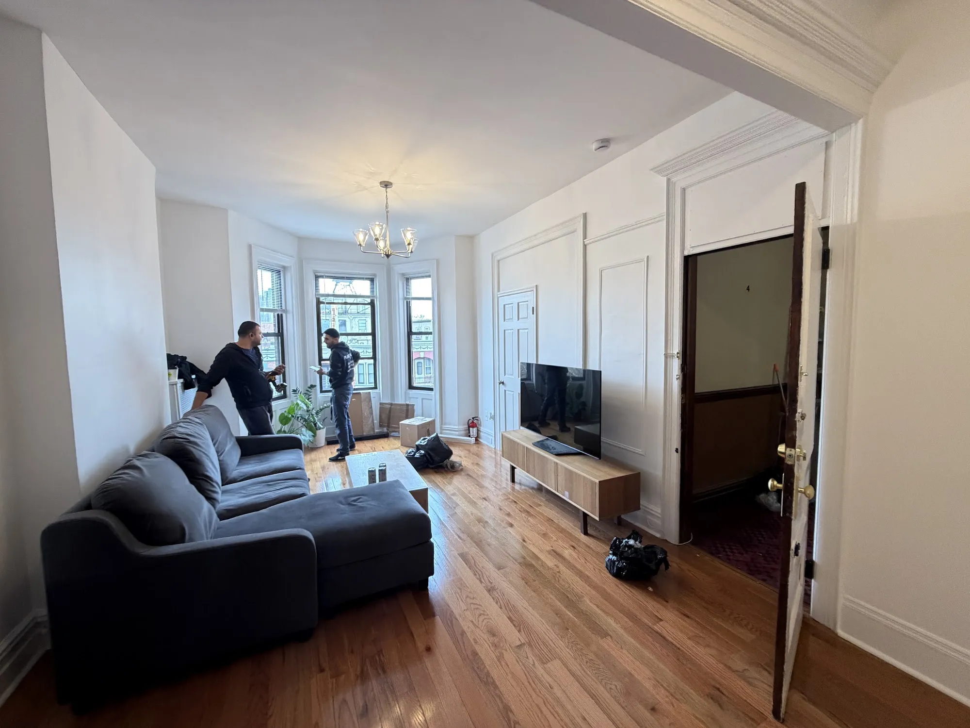 Two Planetary Movers crew members at work in a bright apartment living room
